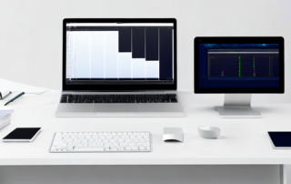 moderner Schreibtisch mit Laptop zeigt Grafiken und Diagramme fuer Performance Marketing